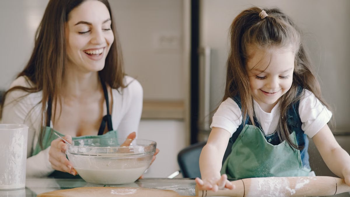 A joyful moment as a mother and daughter bond while baking pastries at home.